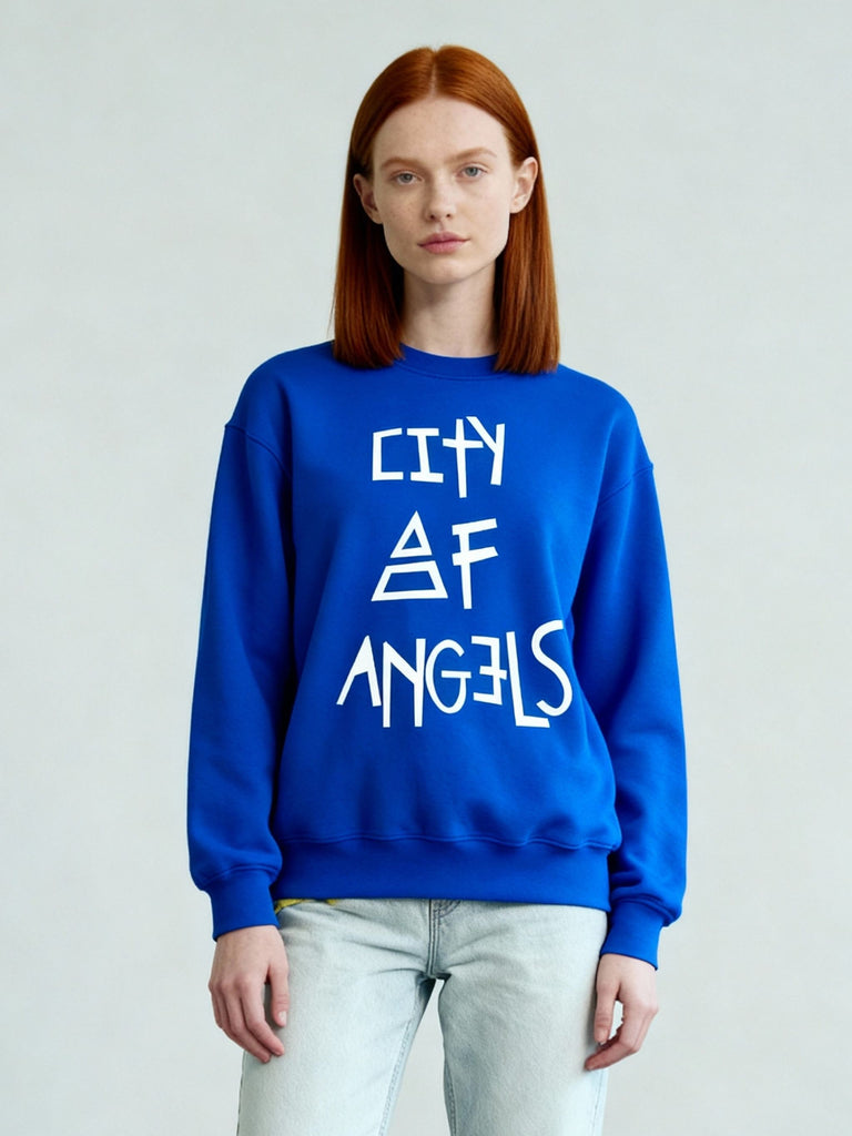 Three-quarter front view of the royal blue City of Angels sweatshirt worn by female model, showcasing relaxed unisex fit and graphic print.