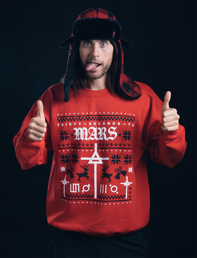 Jared Leto wearing a red 'Thirty Seconds to Mars' holiday sweatshirt with a black background